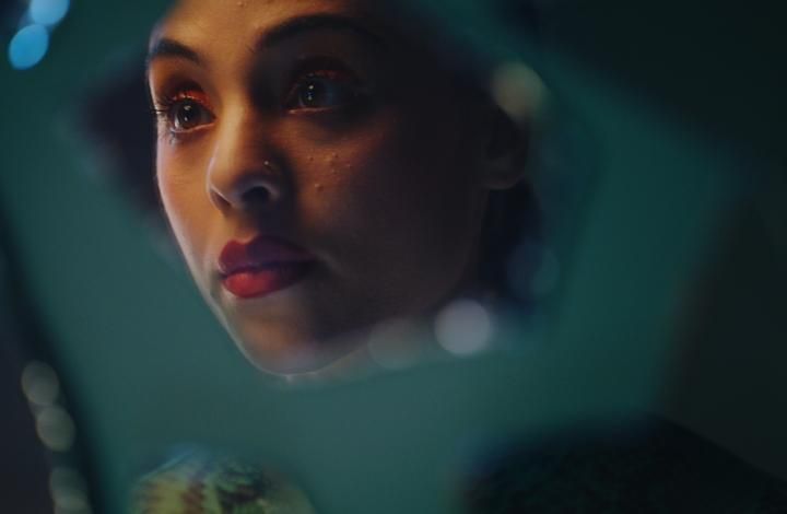 Woman looking at her reflection in glass