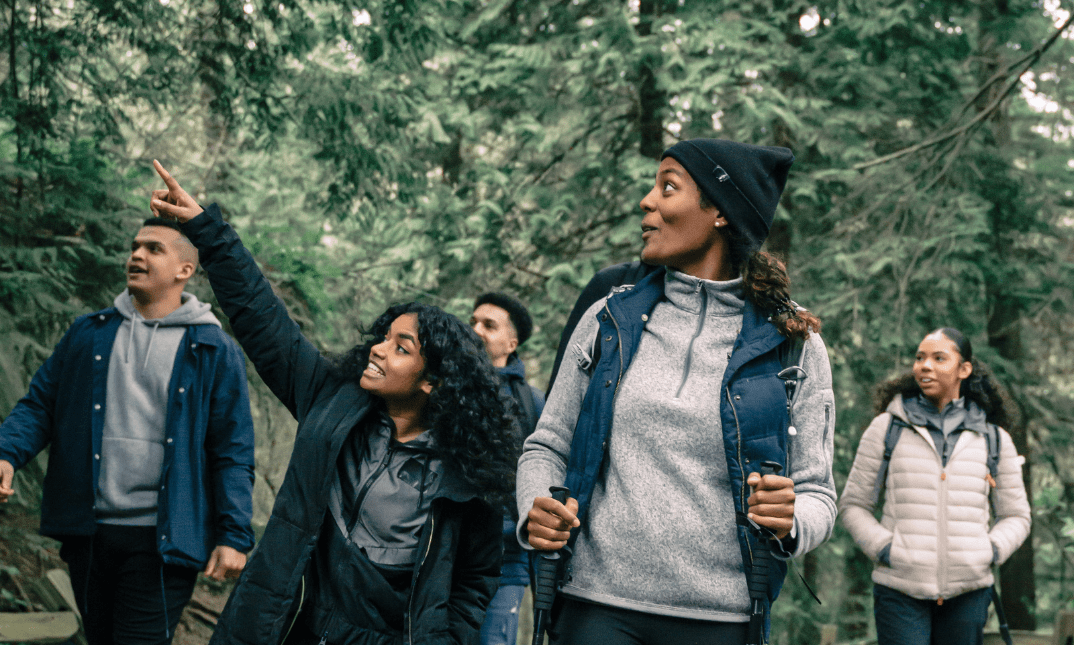 A group of 4 young people hiking in a forest