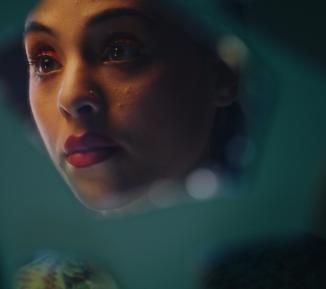 Woman looking at her reflection in glass