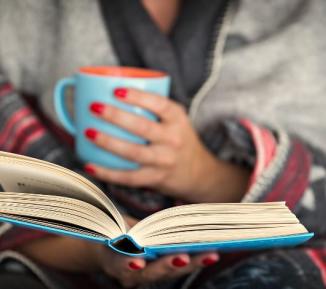 Woman reading a book with a cup of tea