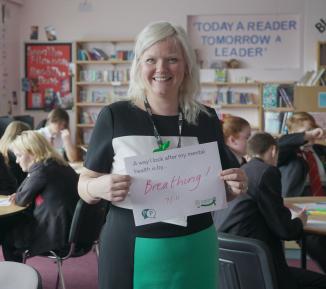 PEP school staff member smiles in front of the class