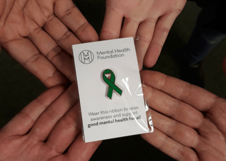 Green ribbon pin badge hands