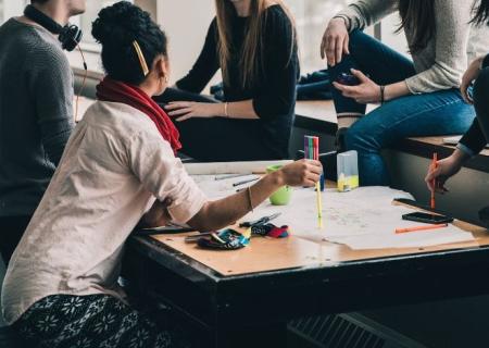 SITUATE group of young people working at a desk