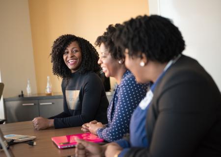 Women in a meeting room smiling