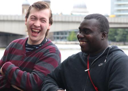 Two men sat outside laughing together