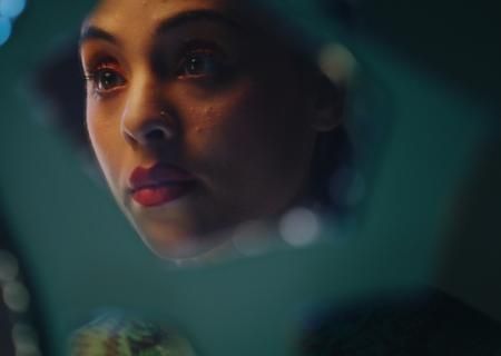 Woman looking at her reflection in glass