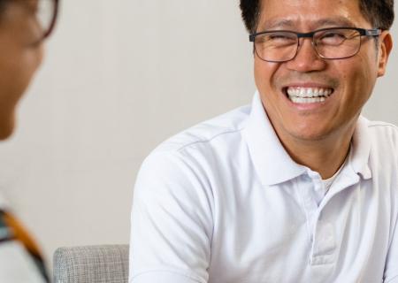 Man smiling and drinking coffee with a friend (portrait)