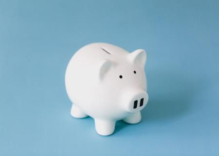 White piggy bank for collecting money on a blue background