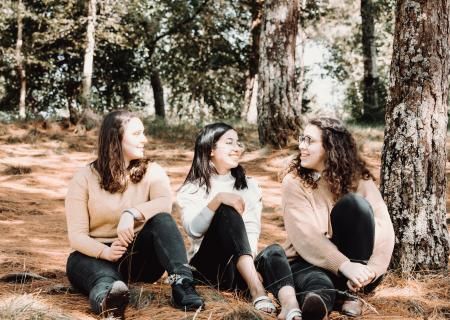 Photo of three friends chatting in the forest