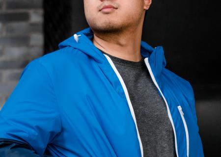 Young man outside in a blue jacket